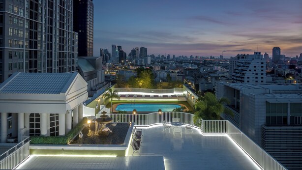 A rooftop pool area with a view of the city skyline at dusk. - The Victory Executive Residences (Bangkok)