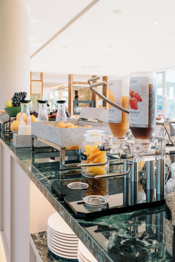 A buffet setup with various food items and a coffee machine. - Smy Pisa Plaza (Pisa)