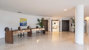 A spacious lobby with a long reception desk, a large abstract painting, and a modern door. - Smy Pisa Plaza (Pisa)