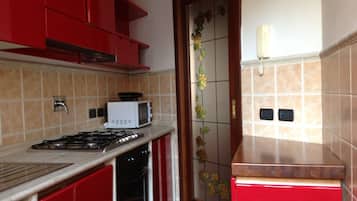 Luxe appartement | Gemeenschappelijke keuken | Een oven, een kookplaat, een vaatwasser, kookgerei, borden en bestek