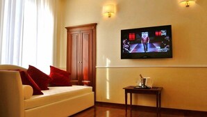 Una sala moderna con un sofá, un televisor montado en la pared y un mueble de madera.