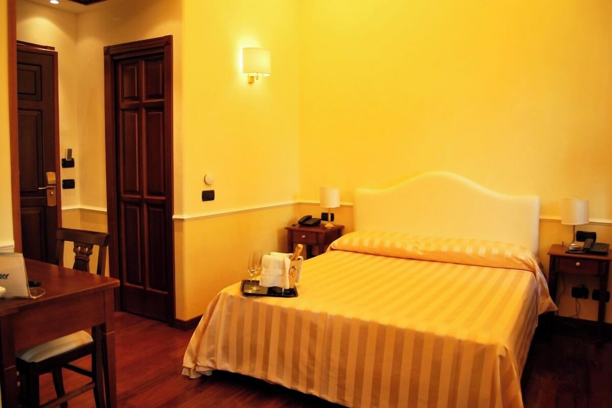 Une chambre d’hôtel comprenant un lit, des tables de chevet, un bureau et une chaise.