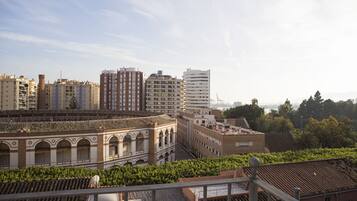 Un paisaje urbano con una mezcla de edificios modernos y tradicionales, incluyendo un edificio destacado con ventanas arqueadas y techo de tejas.
