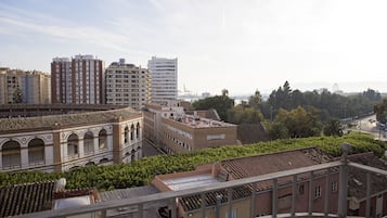 Een hoog gebouw met meerdere verdiepingen, omgeven door andere gebouwen en groen.