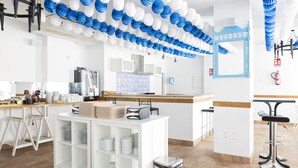 Cocina moderna con armarios blancos, una isla central y una zona de bar con taburetes.