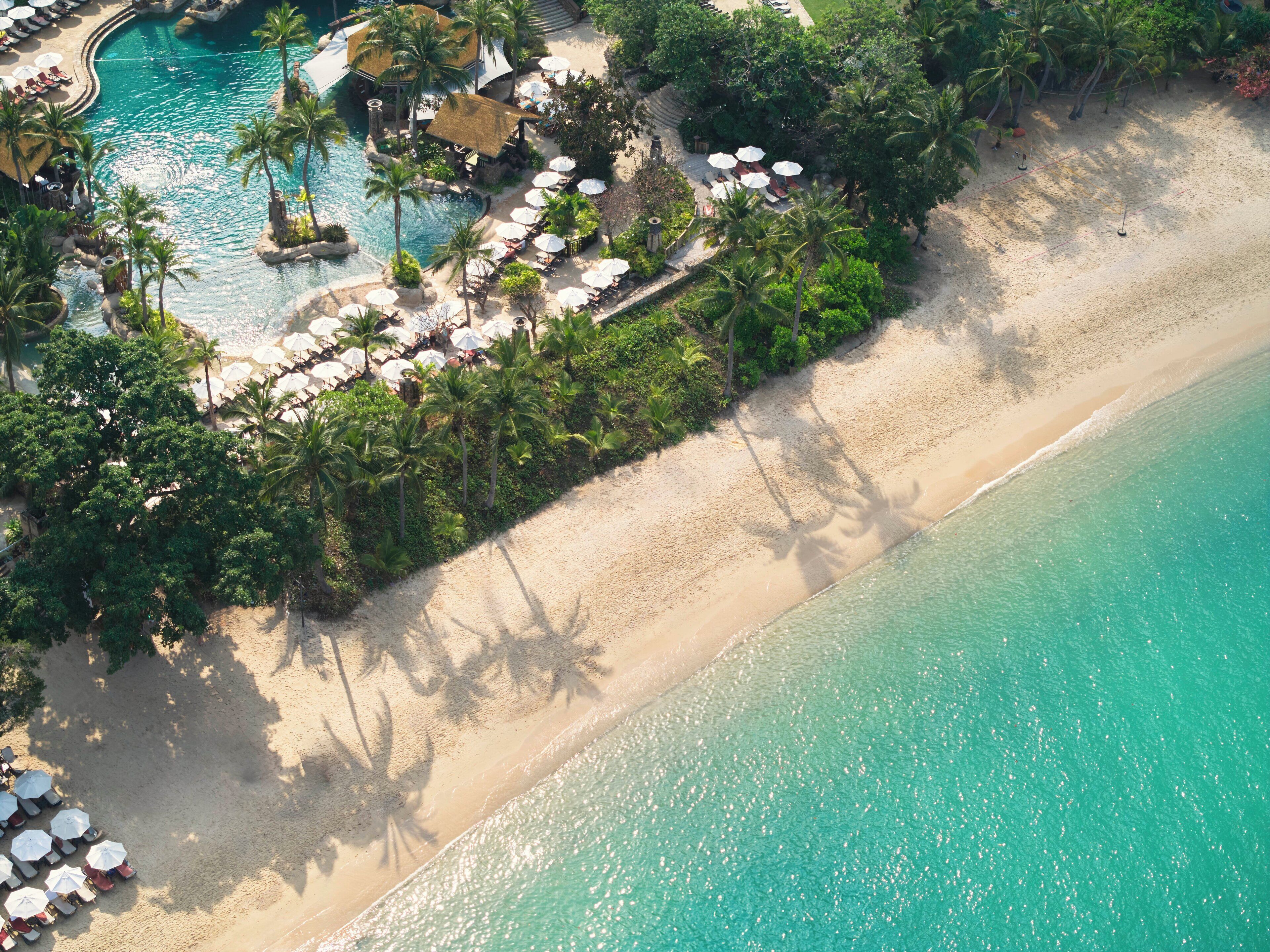 Nyilvános parton, fehér homok, napernyők és strandlepedők