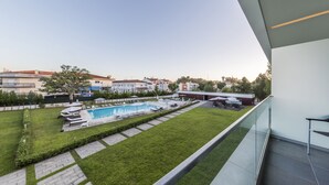 A modern building with a swimming pool, a grassy area, and a view of surrounding buildings. - Monte Real Hotel, Termas & Spa (Leiria)