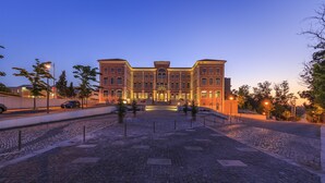 A large, historic building with a symmetrical facade, a central entrance, and a paved courtyard with stone tiles. - Monte Real Hotel, Termas & Spa (Leiria)
