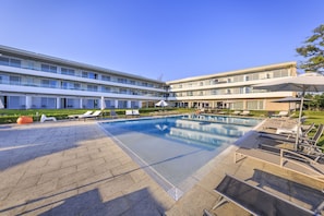 Un hôtel moderne doté d’une piscine centrale, de plusieurs espaces de détente et d’un jardin bien entretenu.