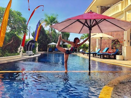 Una piscina al aire libre, sillones reclinables de piscina