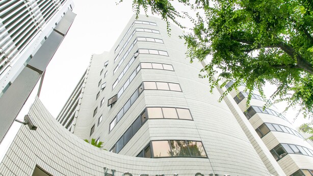 A modern hotel building with a curved facade and the name "HOTEL OCHOEDO" prominently displayed. - Hotel Ohedo (Tokyo)