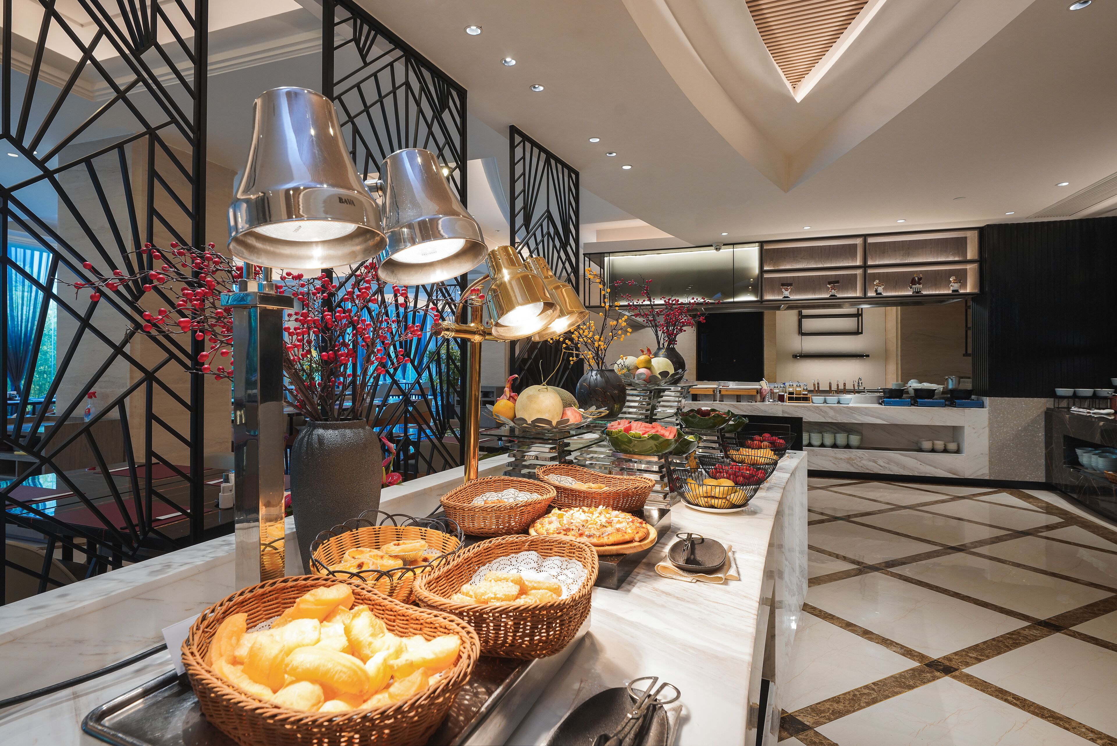Un'impostazione a buffet con diversi piatti e cesti di cibo, un vaso decorativo e un design d'interni moderno.