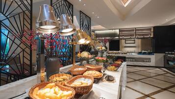 Un'impostazione a buffet con diversi piatti e cesti di cibo, un vaso decorativo e un design d'interni moderno.