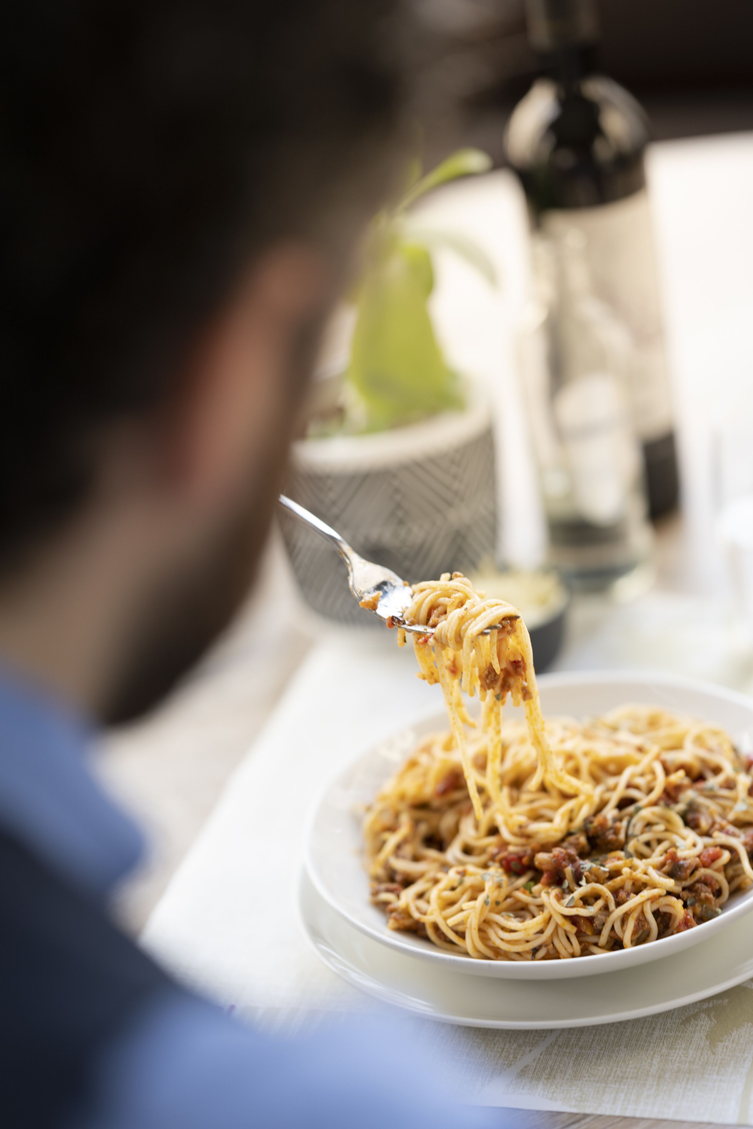 Una persona comiendo espagueti con un tenedor.