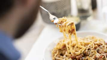A person eating spaghetti with a fork.