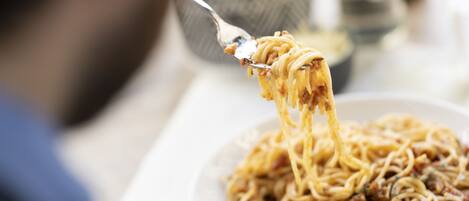A person eating spaghetti with a fork.
