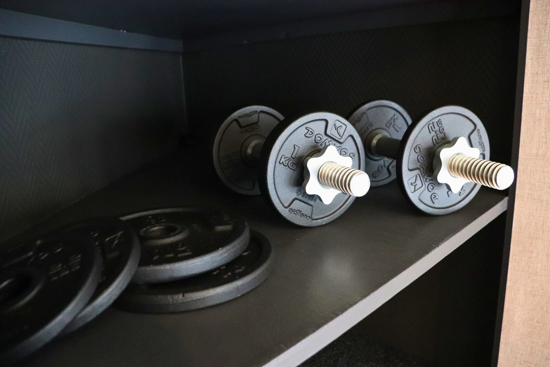 Estante para pesas con mancuernas ajustables en un gimnasio.