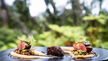 Une assiette de nourriture comprenant trois morceaux de viande et quelques légumes verts.