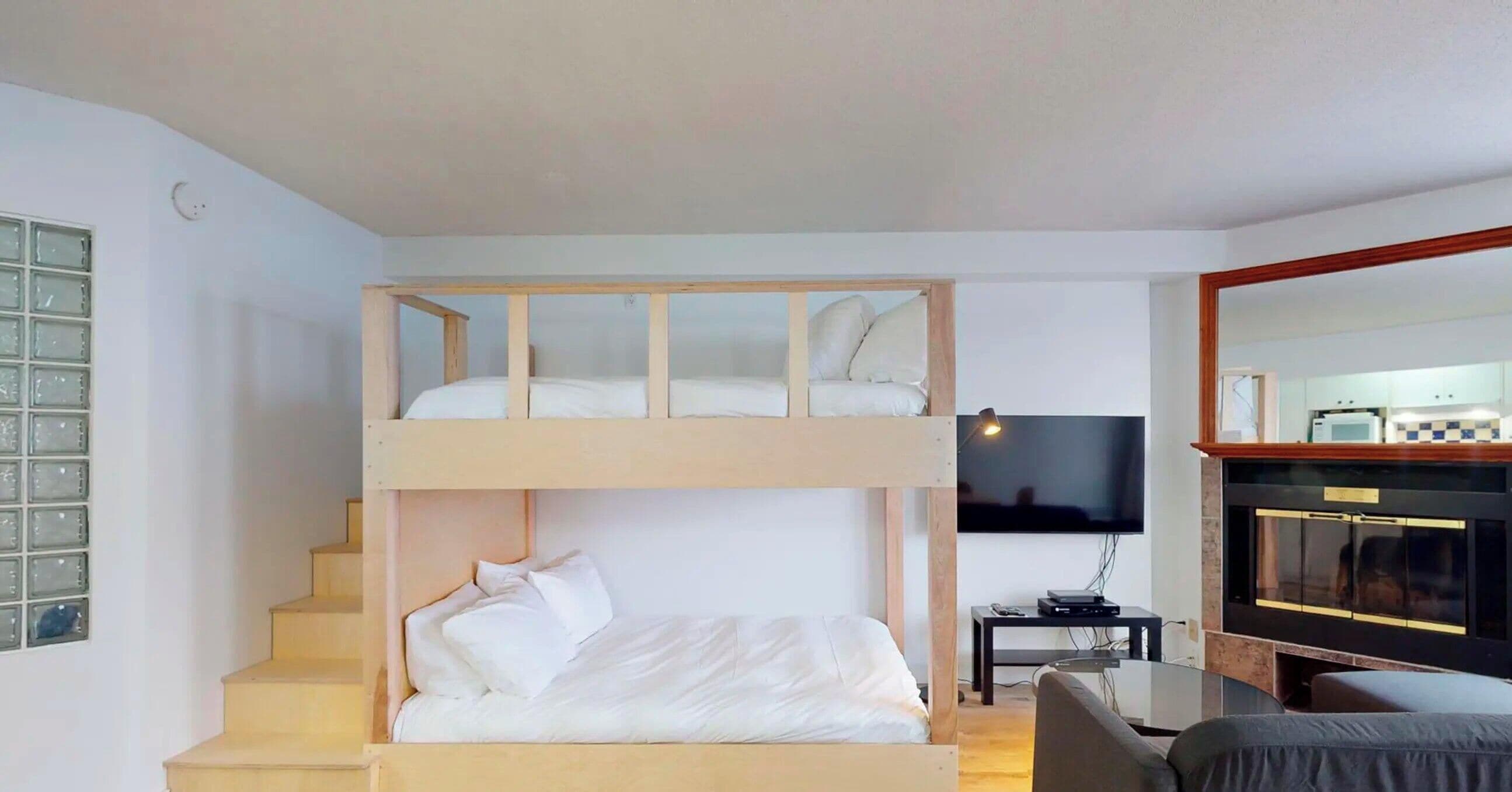Habitación con literas, un escritorio y un televisor.