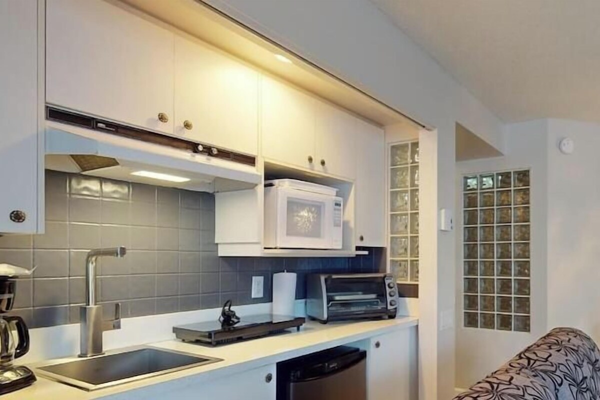 A modern kitchen with a built-in microwave, a coffee machine, and a dishwasher.