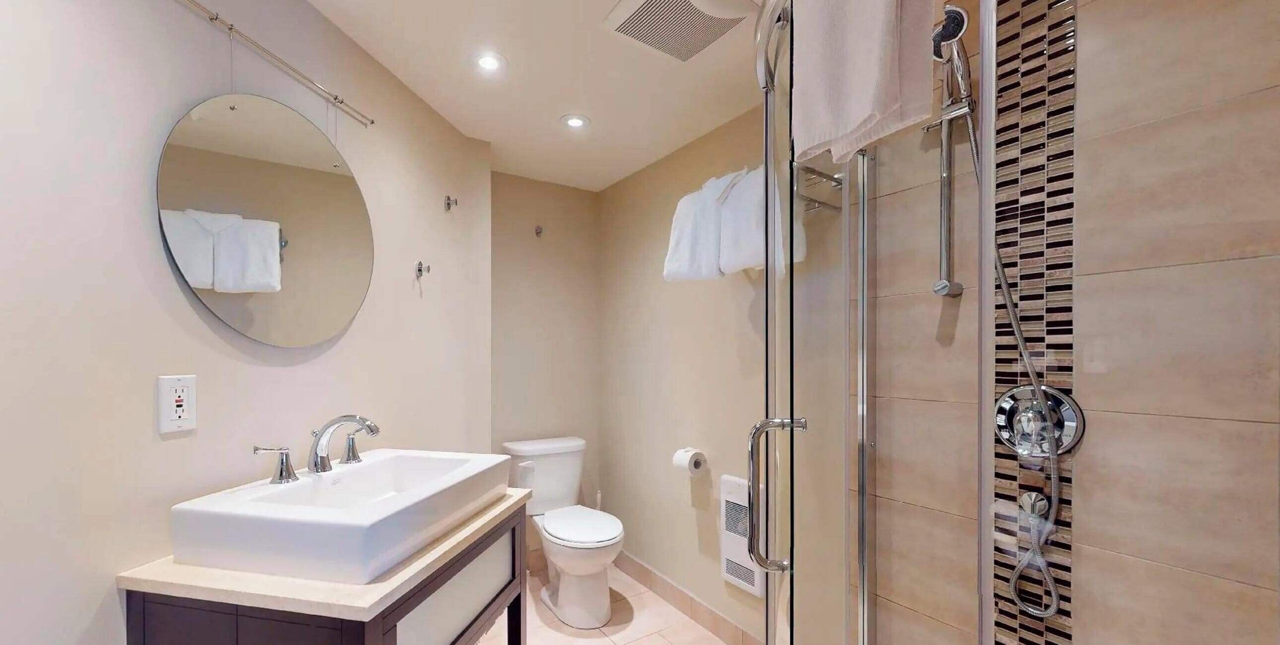 Un baño con lavabo, espejo, inodoro y ducha.