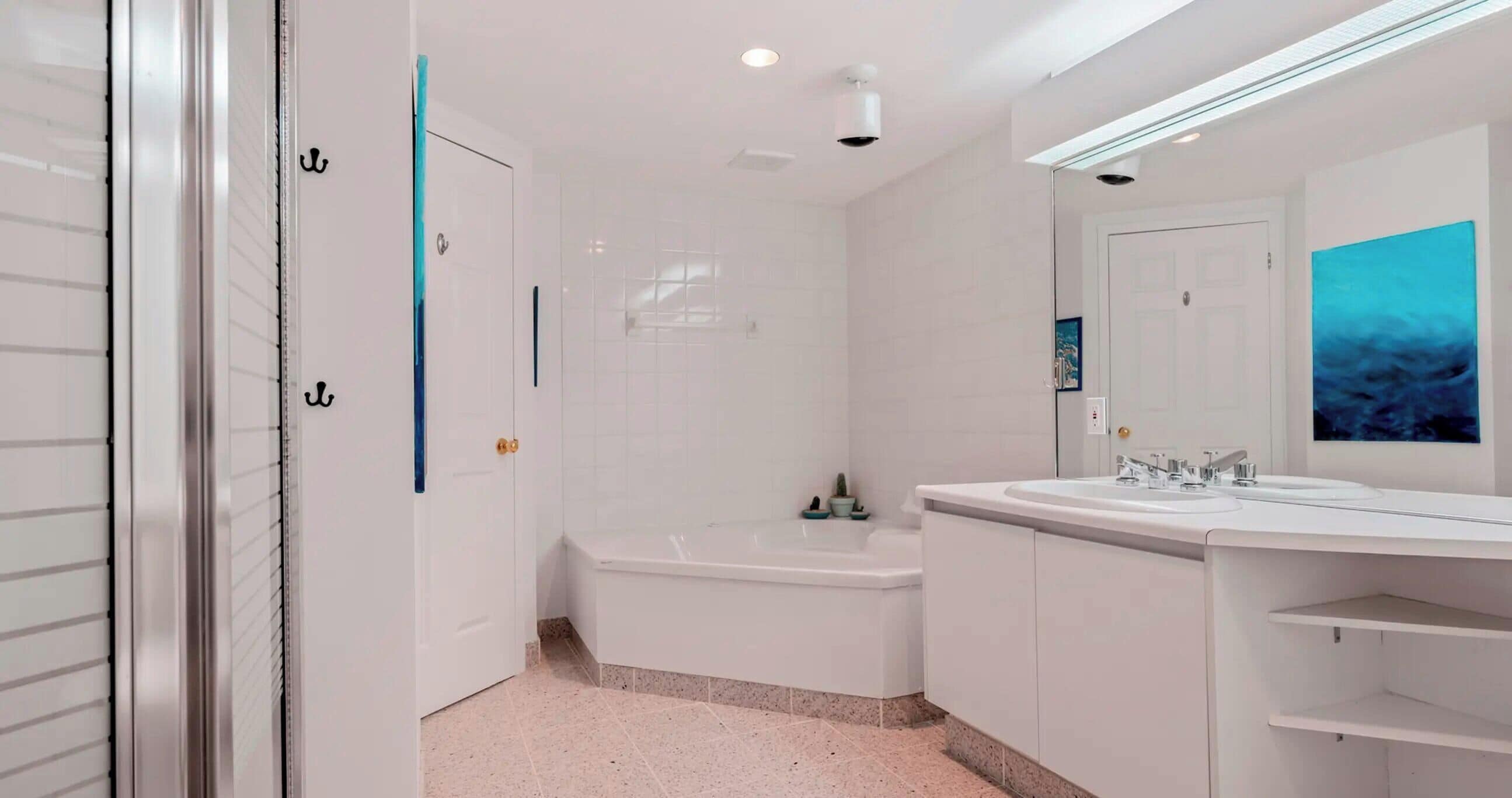 Een moderne badkamer met een bad, een grote spiegel en een wastafel.