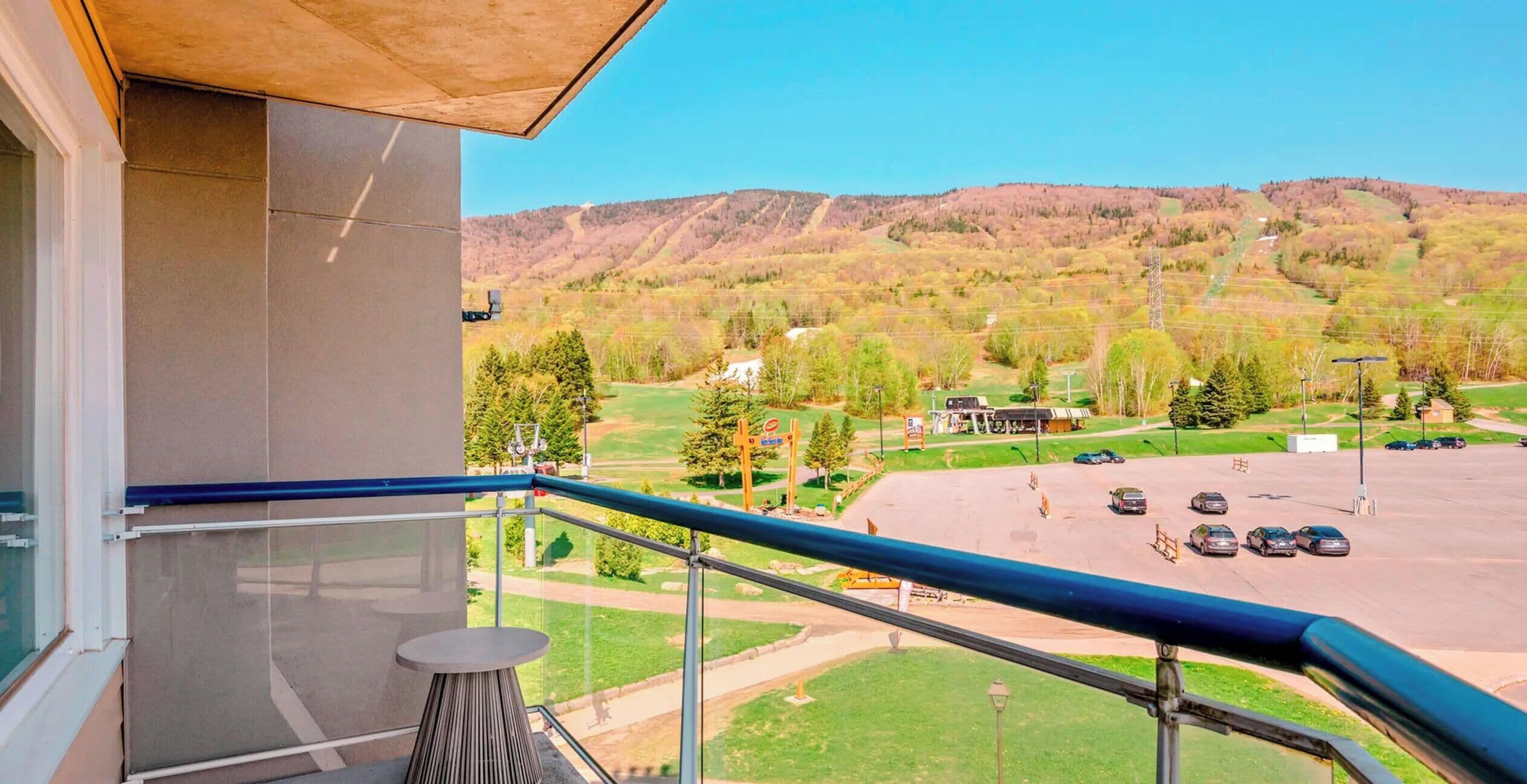 A balcony with a view of a parking lot and a golf course.