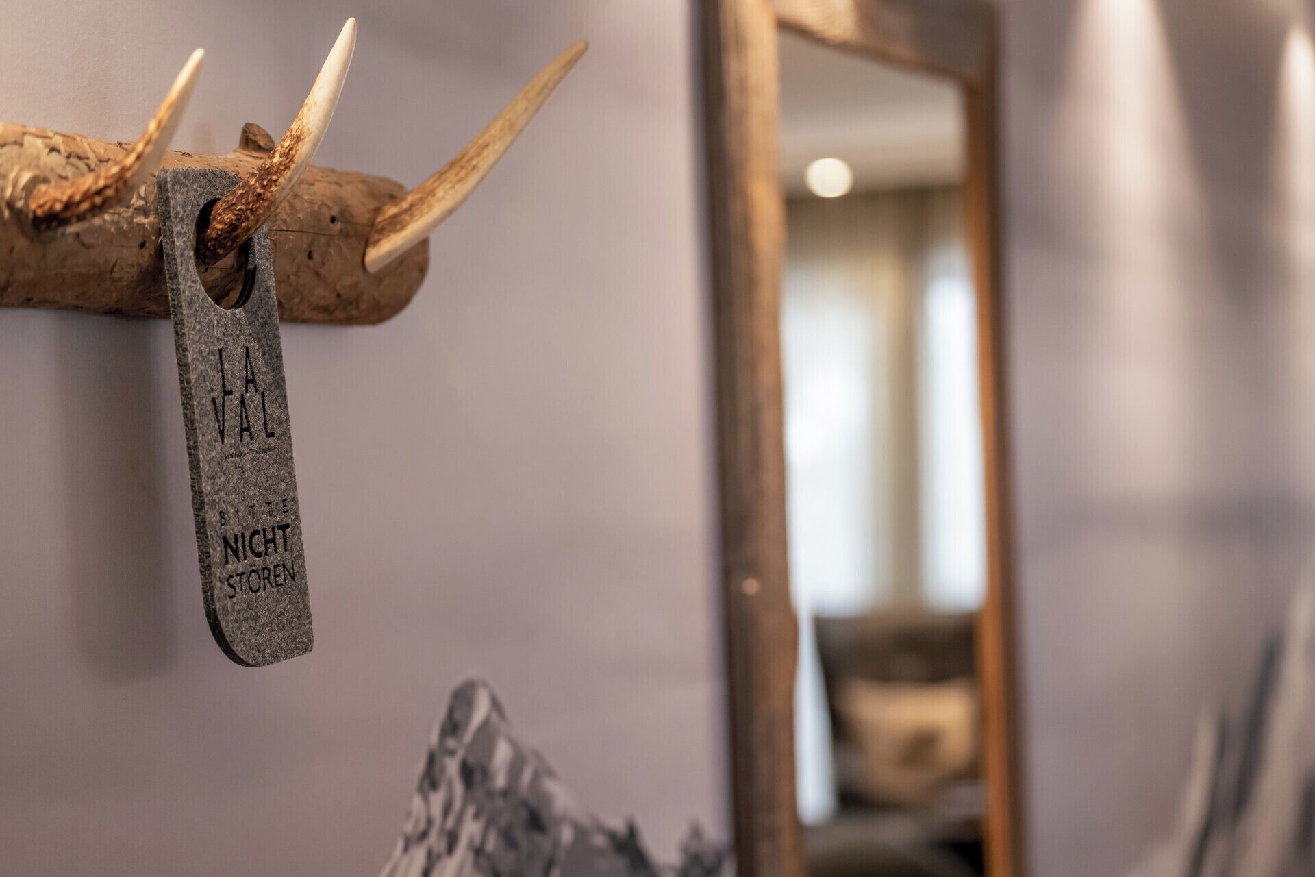 Eine hölzerne Plakette mit Geweihen und der Aufschrift 'NIGHT STORE', die an einer Wand hängt.