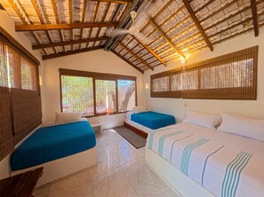 A room with two beds, a ceiling fan, and a window with blinds. - Hotel PlayaScondida Baru (Cartagena)