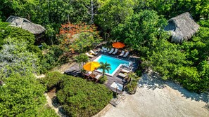 Una piscina al aire libre, sombrillas, tumbonas