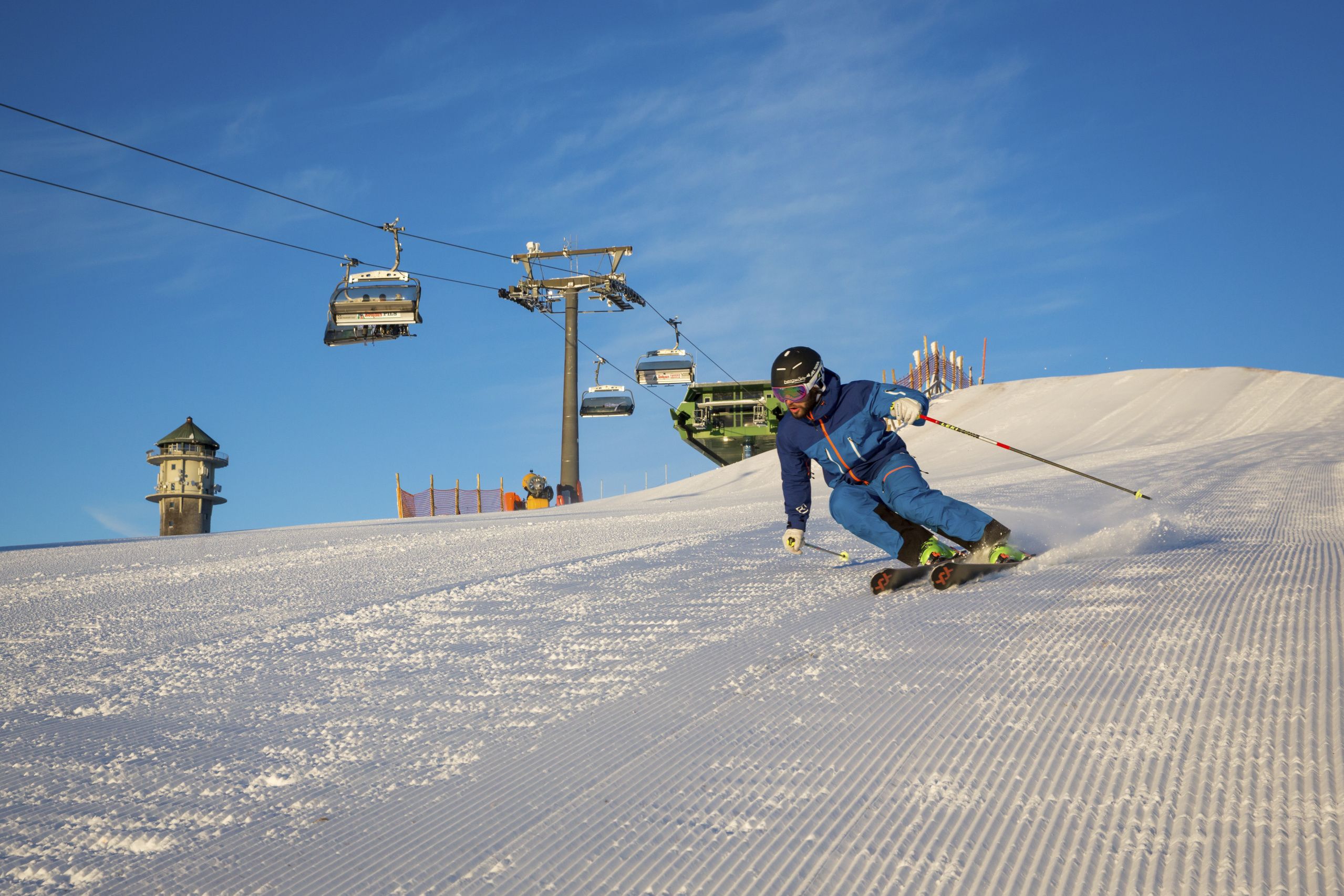 A ski slope with a ski lift and a tower.