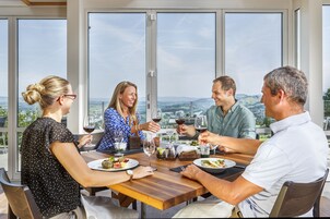 A group of people dining at a table with a city view.