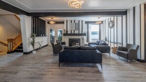 Amplia sala de estar con chimenea, muebles modernos y una escalera que lleva a otro nivel.