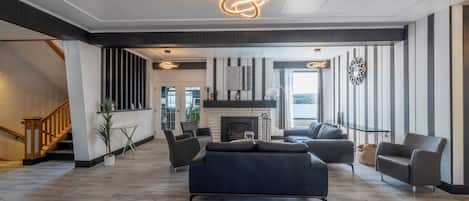 Amplia sala de estar con chimenea, muebles modernos y una escalera que lleva a otro nivel.
