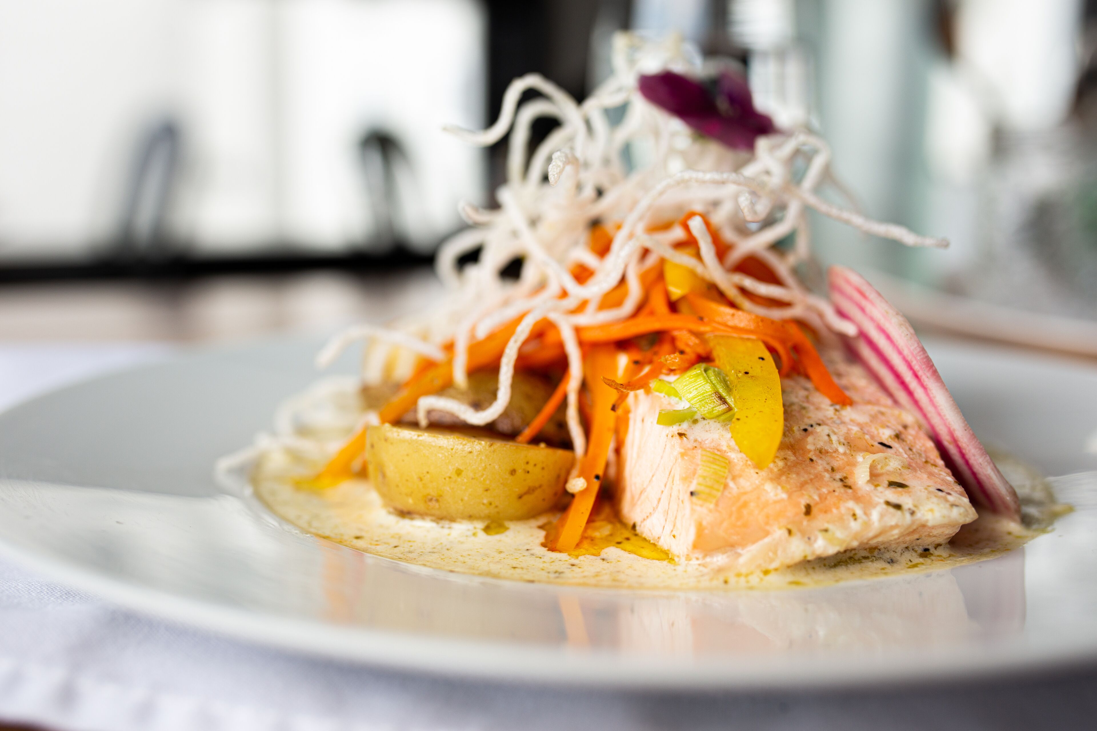 Ein Teller mit Lachs, Gemüse und einer dekorativen Dekoration.