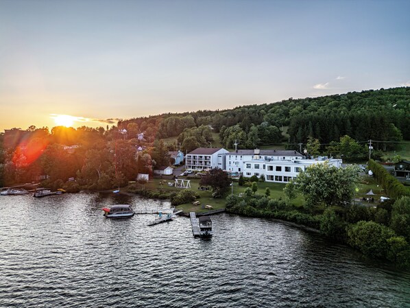 A lakeside hotel with a dock, boats, and a large building with multiple windows. - Le Manoir Lac-Etchemin (Lac-Etchemin)