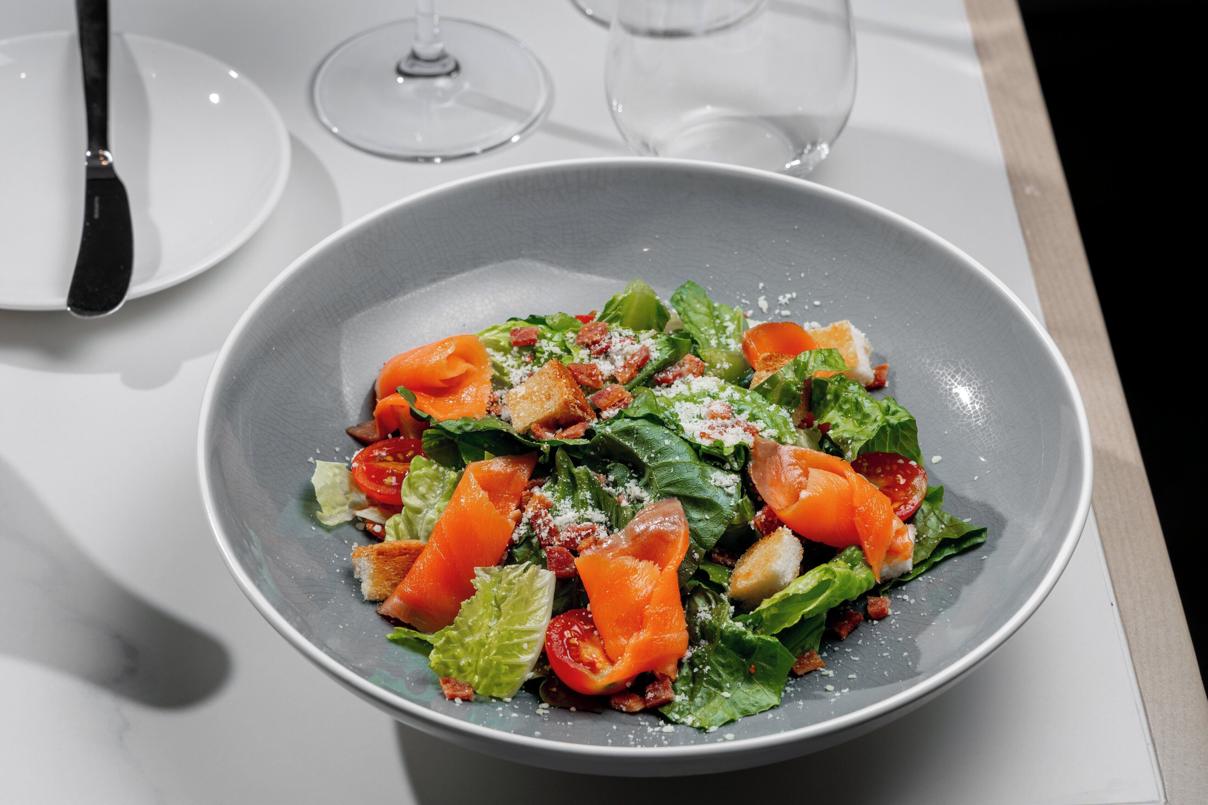 Een salade met croutons en kaas op een tafel.