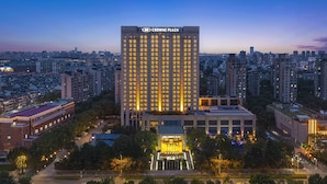 A high-rise hotel with a prominent "Crowne Plaza" sign, surrounded by other buildings and a well-lit entrance area. - Crowne Plaza Shanghai Jinxiu by IHG (Shanghai)