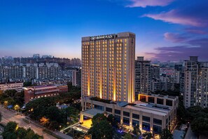 A high-rise hotel with a prominent 'Crown Plaza' sign, surrounded by dense urban buildings. - Crowne Plaza Shanghai Jinxiu by IHG (Shanghai)