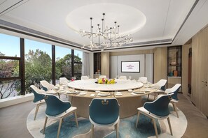 A conference room with a round table, blue chairs, and a chandelier. - Crowne Plaza Shanghai Jinxiu by IHG (Shanghai)