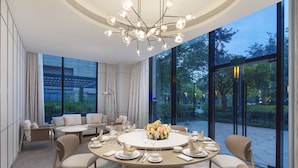 A modern dining area with a round table set for four, surrounded by comfortable seating. - Crowne Plaza Shanghai Jinxiu by IHG (Shanghai)
