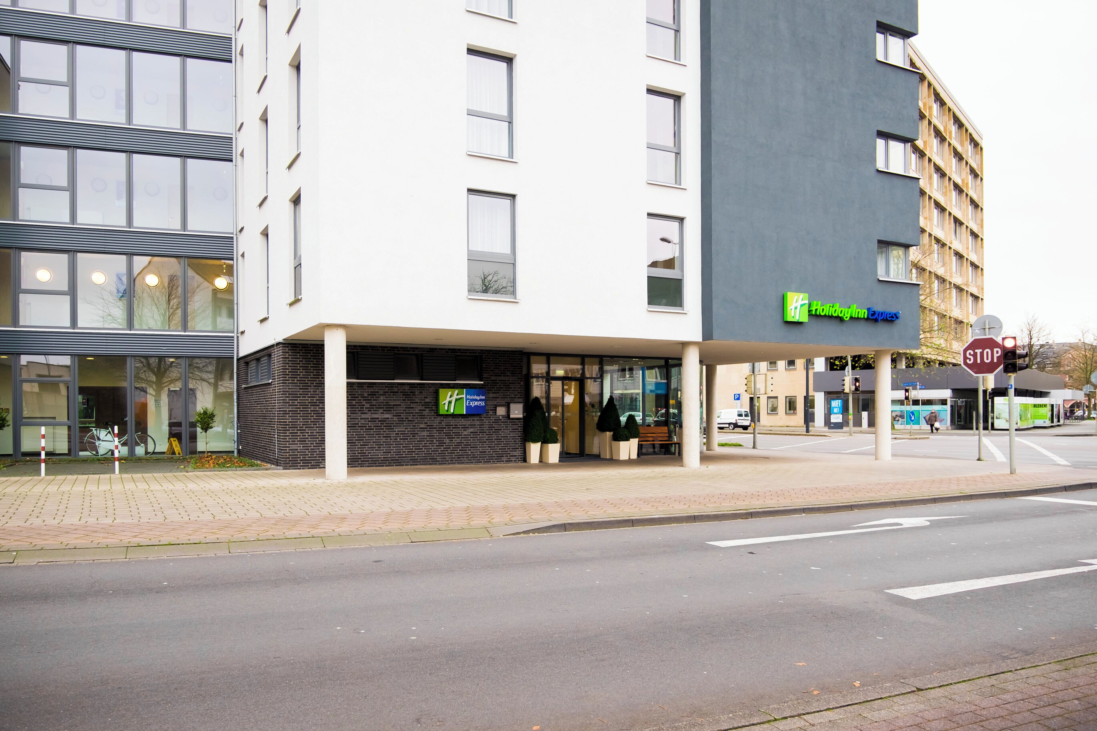 Ein Holiday Inn Express Hotel mit moderner Fassade, großen Fenstern und einem gut sichtbaren Eingang.