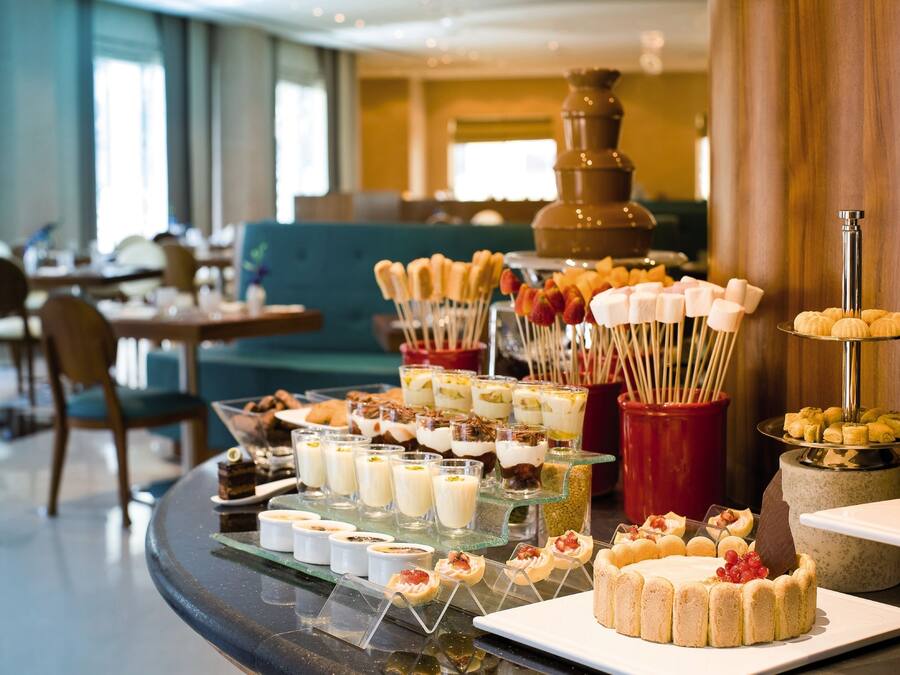 Buffet com diversos doces e uma fonte de chocolate quente.