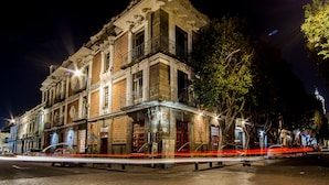 Un edificio histórico con fachada clásica, ventanas amplias y un balcón.