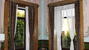 Una habitación con papel pintado ornamentado, un candelabro y una alfombra estampada.