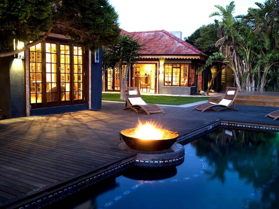 Een buitenzwembad, ligstoelen bij het zwembad