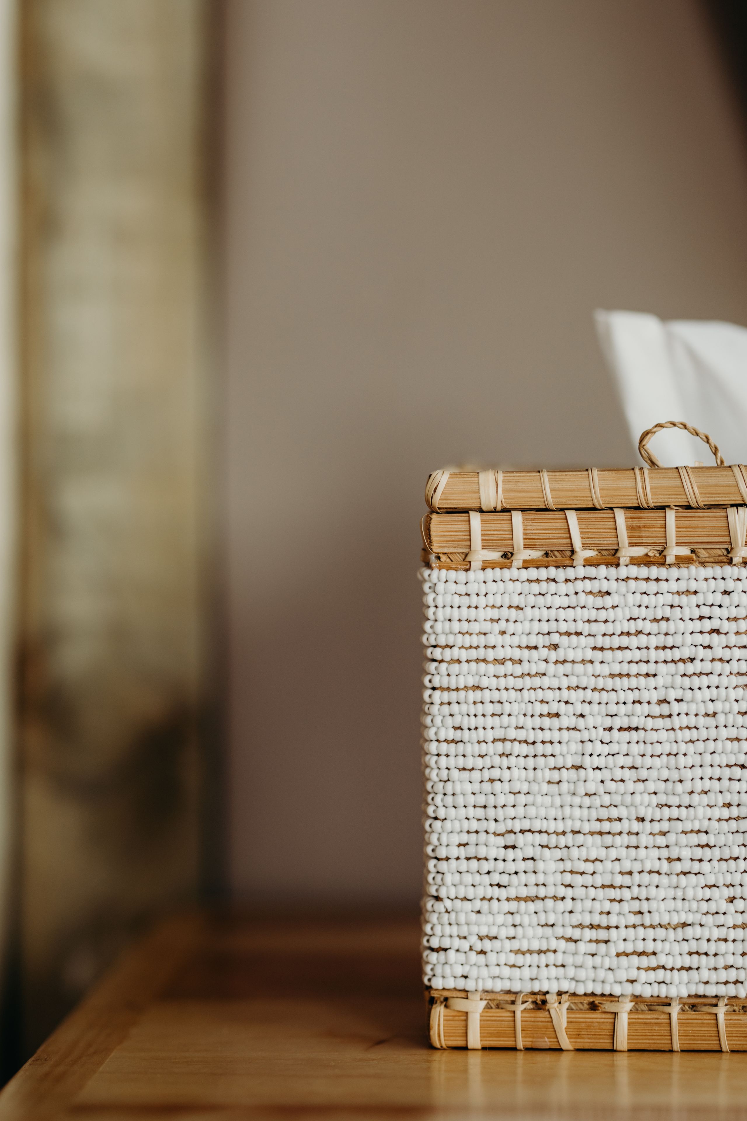 A wicker basket with a handle on a wooden surface.