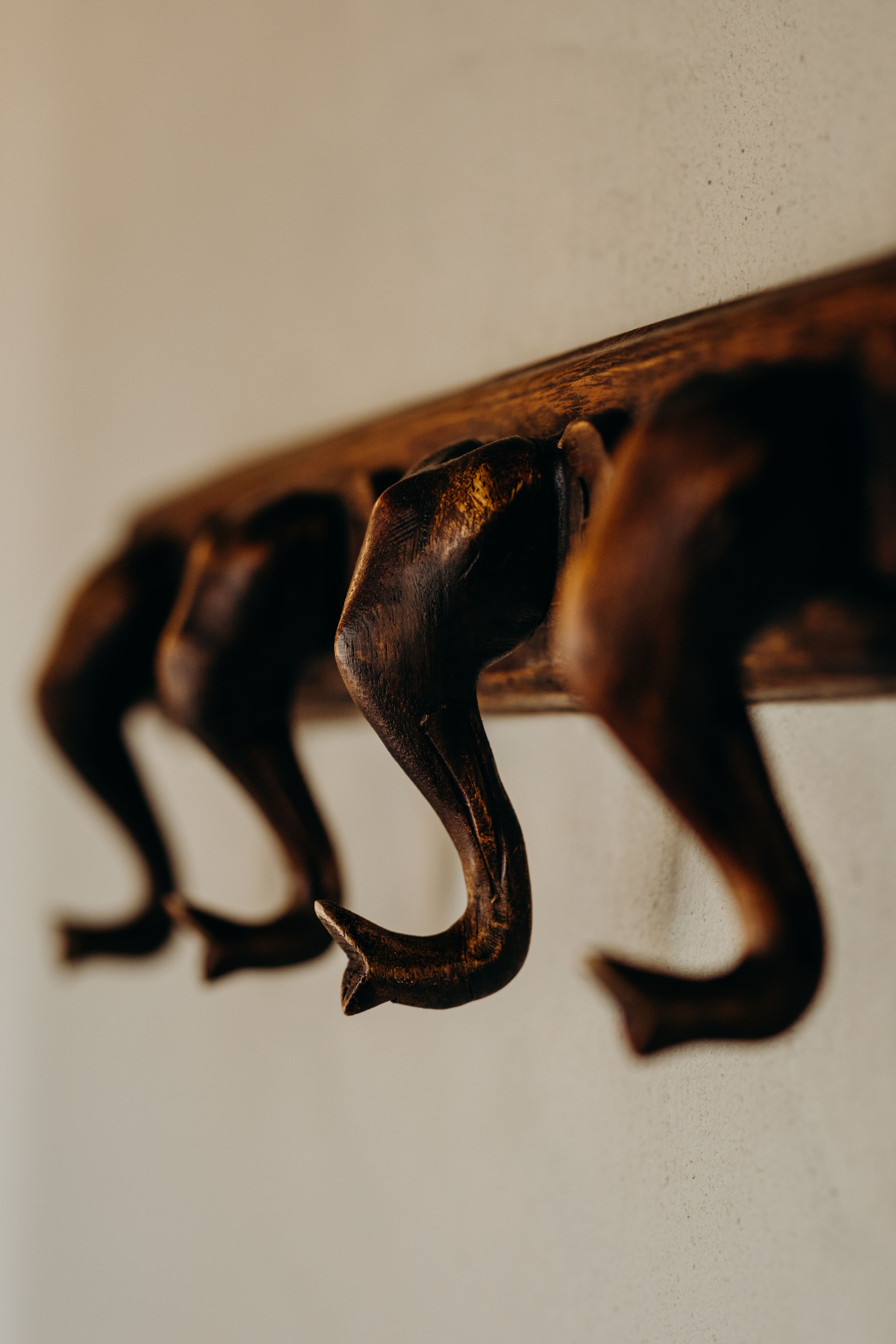 A close-up of a wooden wall with three metal hooks.