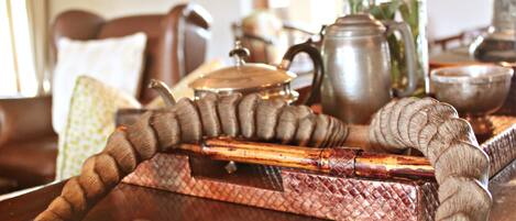 A wooden tray with a woven edge, a metal pot, and a wooden spoon.