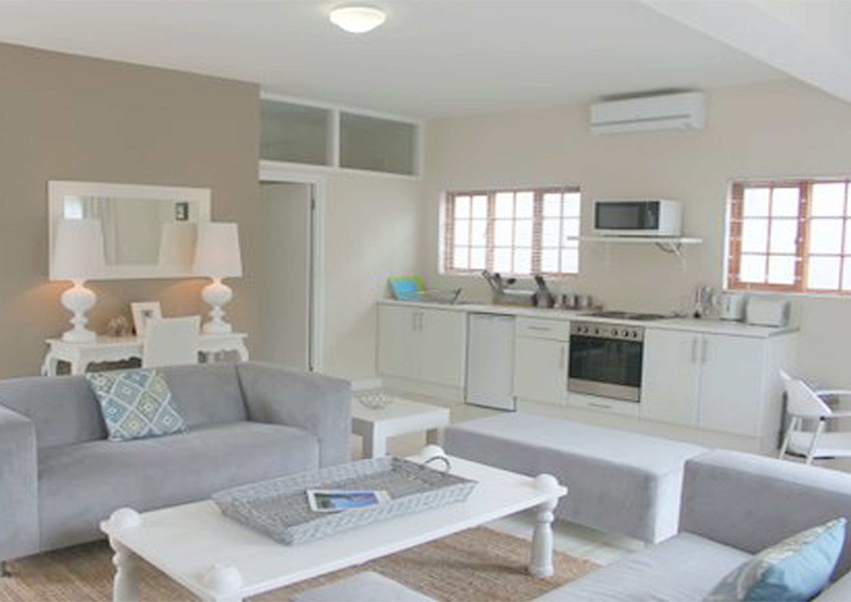 A compact living space with a kitchenette, a sofa, a coffee table, and a dining area.